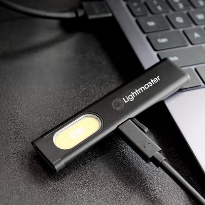 Lightmaster USB LED work light plugged into laptop on black textured surface